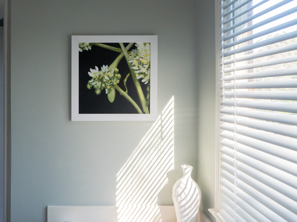 "A Tiny Weed Study" hanging in a bathroom with a white frame